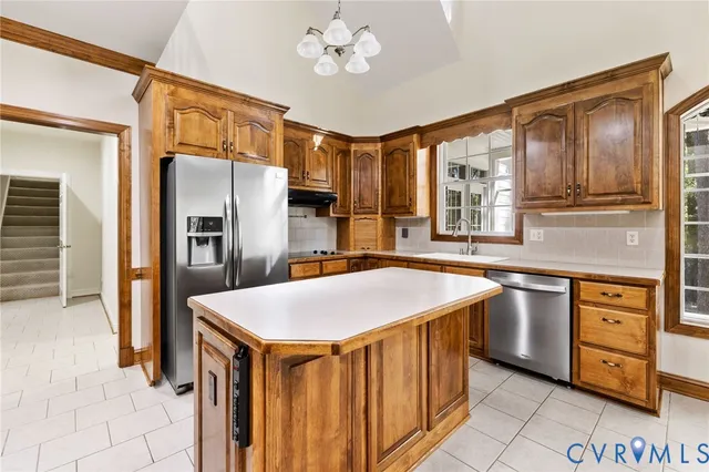 a kitchen with stainless steel appliances granite countertop a sink refrigerator and cabinets