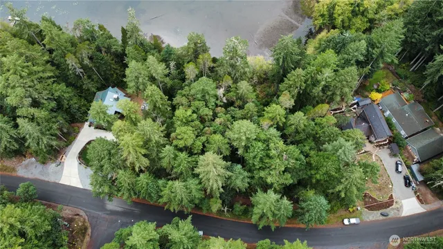 an aerial view of a house with a yard outdoor seating and lake view