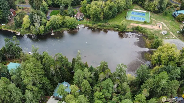 an aerial view of a house with a yard and lake view