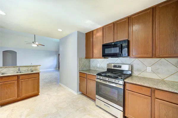 a kitchen with stainless steel appliances a stove a microwave and sink
