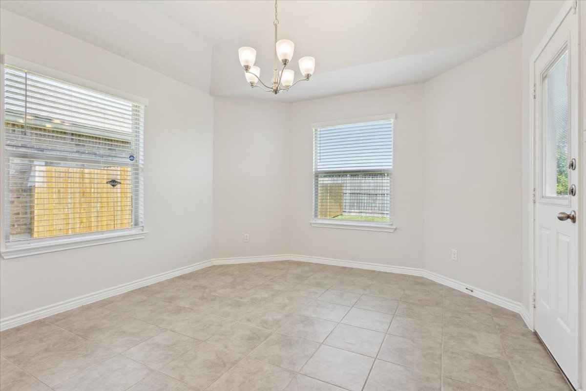 5830 Copano Road Belton, TX 76513 - Photo 12 of 34 Unfurnished room with light tile patterned floors, baseboards, an inviting chandelier, and a healthy amount of sunlight