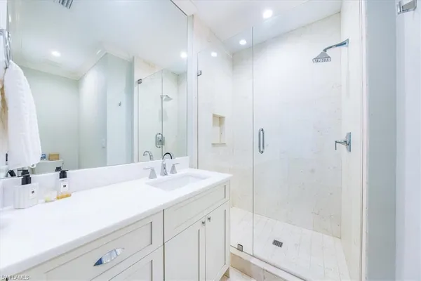 a bathroom with a shower sink vanity and mirror