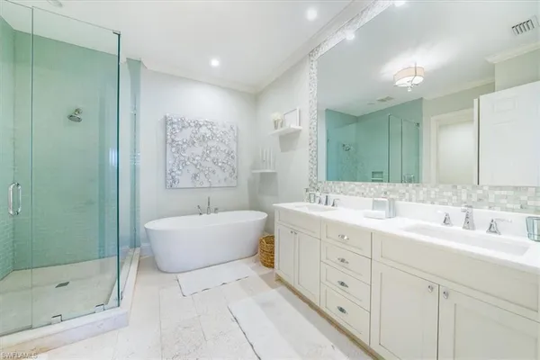 a spacious bathroom with a double vanity sink mirror and bathtub