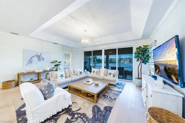 a living room with furniture flat screen tv and a large window