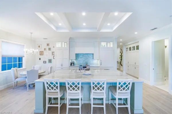 a kitchen with a dining table chairs and wooden floor