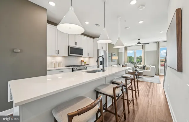 a kitchen with stainless steel appliances a stove a sink a microwave a refrigerator and cabinets