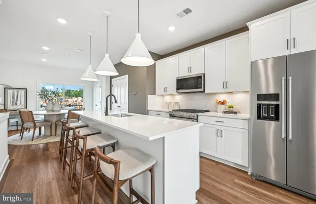 a kitchen with stainless steel appliances kitchen island granite countertop a stove a sink and a microwave