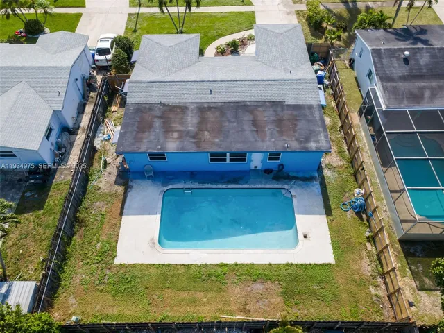 an aerial view of a residential houses with outdoor space and swimming pool