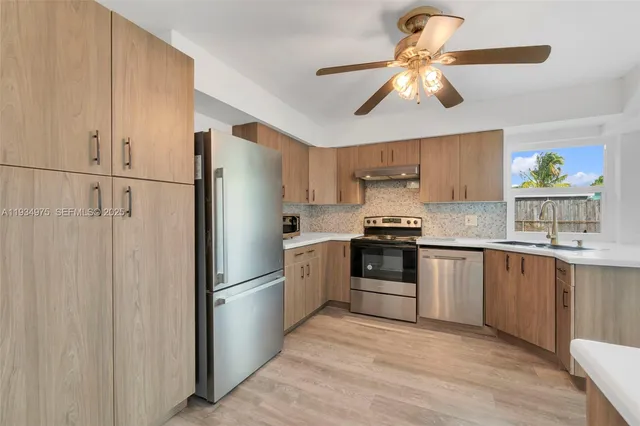 a kitchen with stainless steel appliances a refrigerator sink and cabinets