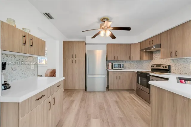 a kitchen with a sink a counter top stainless steel appliances and cabinets