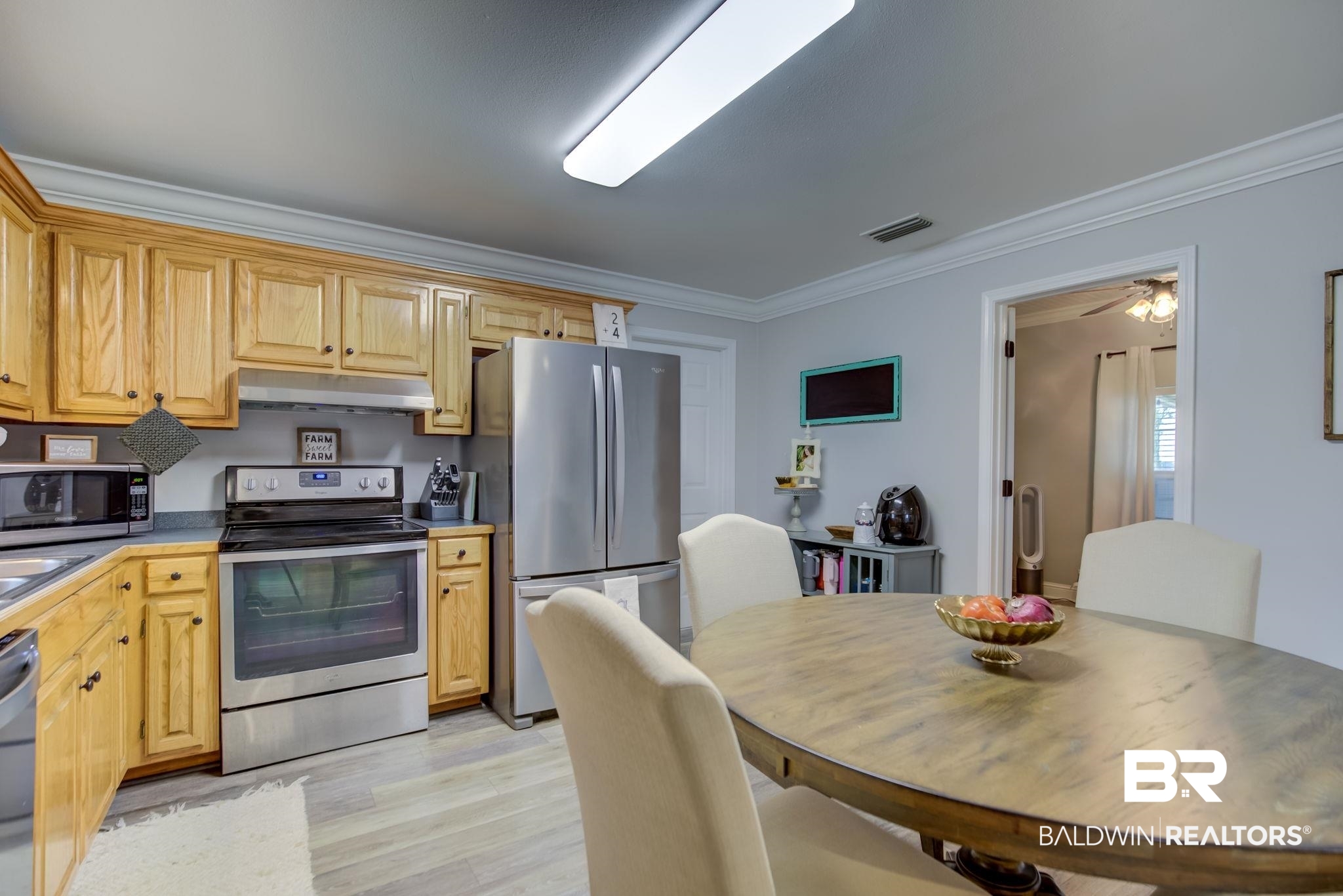 18732 Fairground Road Robertsdale, AL 36567 - Photo 16 of 46 Kitchen featuring stainless steel appliances, light hardwood / wood-style floors, ornamental molding, and ceiling fan