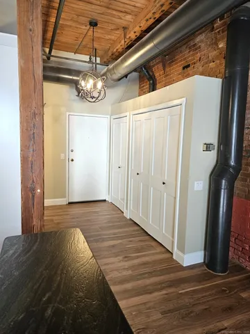 a view of a hallway with wooden floor and staircase