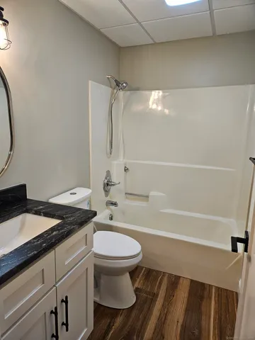 a bathroom with a granite countertop toilet sink and shower