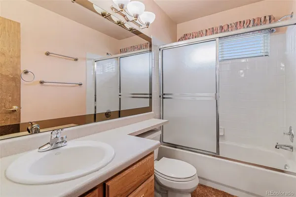 a bathroom with a sink a toilet and shower a mirror