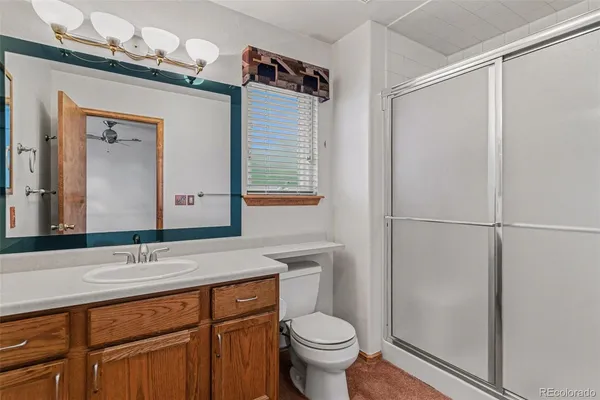 a bathroom with a granite countertop sink toilet and shower