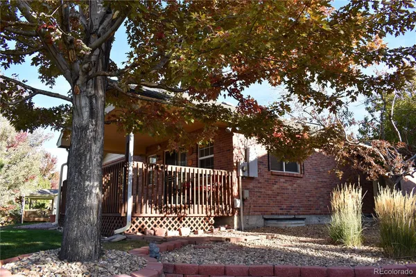 a front view of a house with a tree