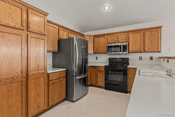 a kitchen with stainless steel appliances granite countertop a refrigerator stove and sink