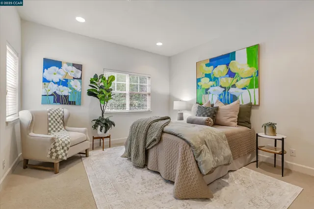 a bedroom with two beds and a potted plant