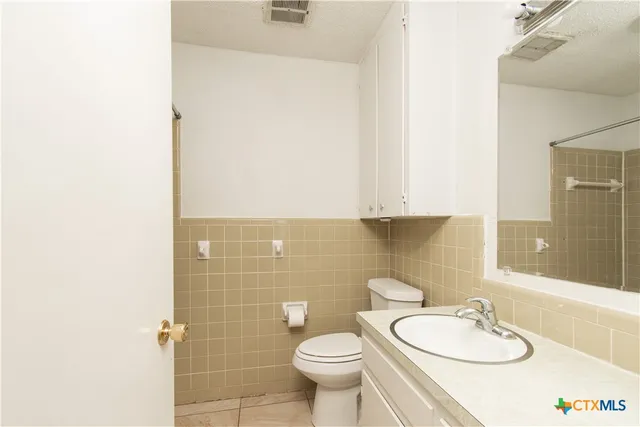 a bathroom with a toilet a sink and mirror