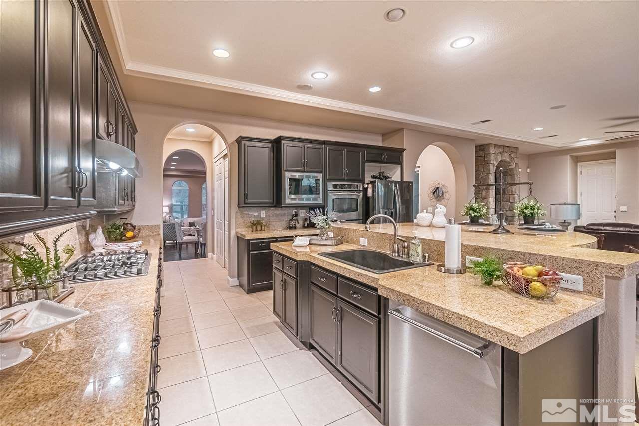 2610 Fury Court Reno, NV 89521 - Photo 3 of 25 a kitchen with stainless steel appliances kitchen island granite countertop a sink and cabinets