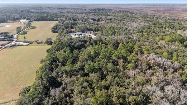 an aerial view of a house with a yard and lake view