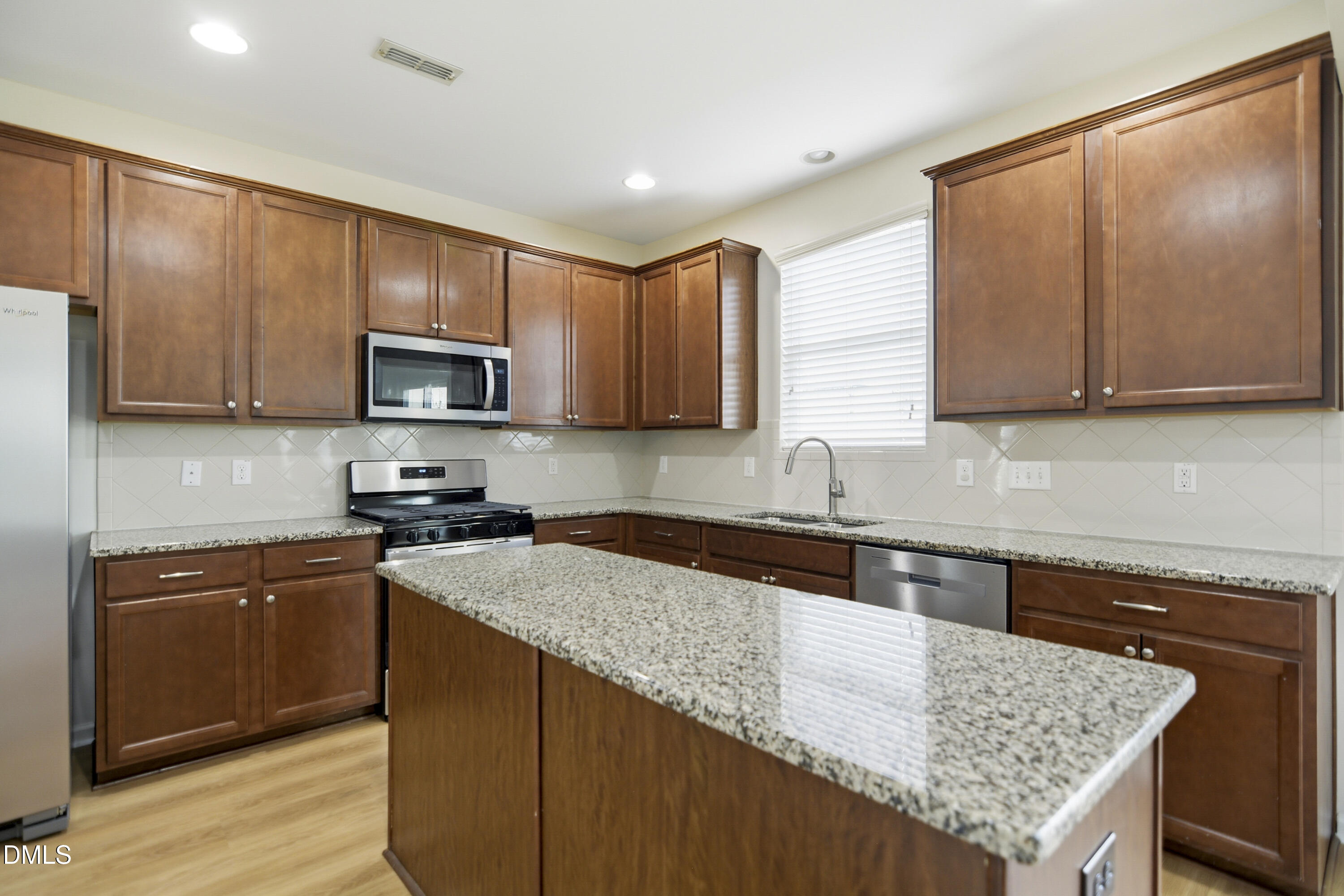 3905 Massey Pointe Court Raleigh, NC 27616 - Photo 5 of 12 a kitchen with stainless steel appliances granite countertop a sink stove microwave and cabinets