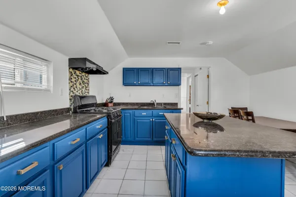 a kitchen with granite countertop a sink and a stove