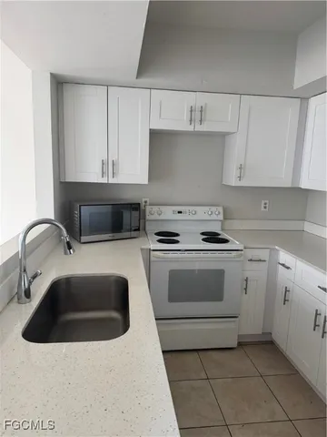 a kitchen with white cabinets and white appliances