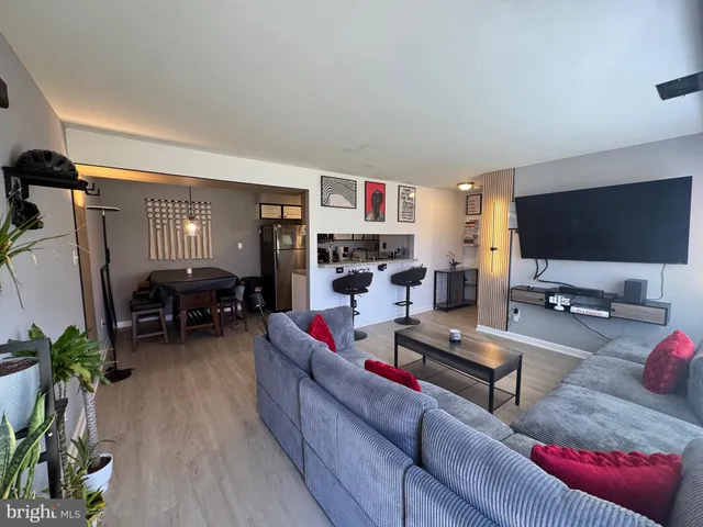 a living room with furniture and a flat screen tv with wooden floor