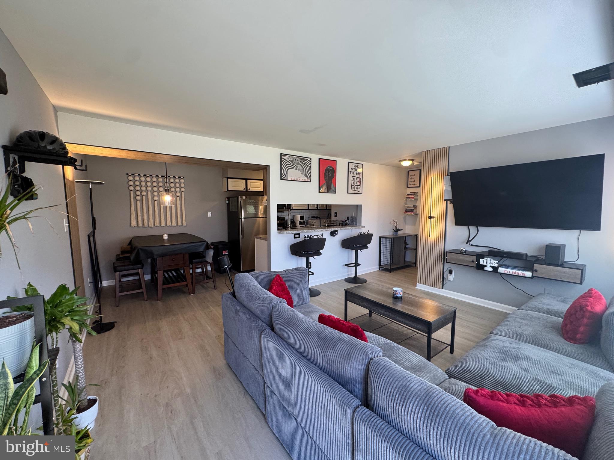 3079 Chester Grove Road, Unit 42E Upper Marlboro, MD 20774 - Photo 1 of 20 a living room with furniture and a flat screen tv with wooden floor