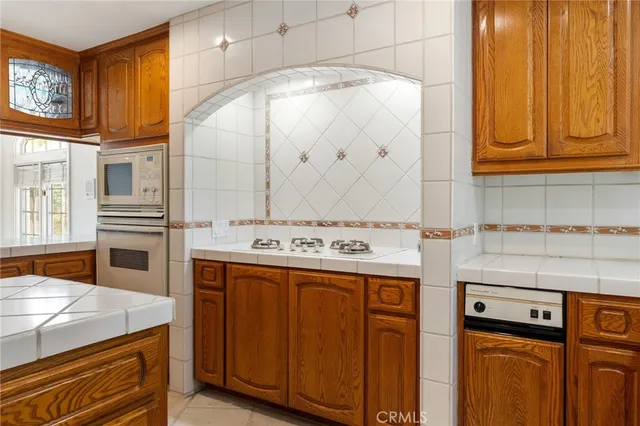 a kitchen with granite countertop a sink a counter top space appliances and cabinets