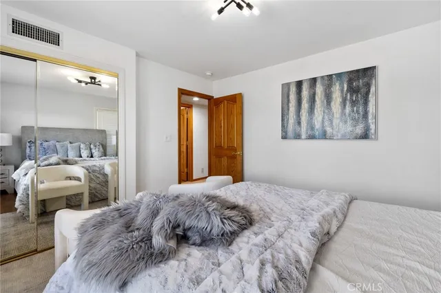 a bedroom with a large bed and a chandelier