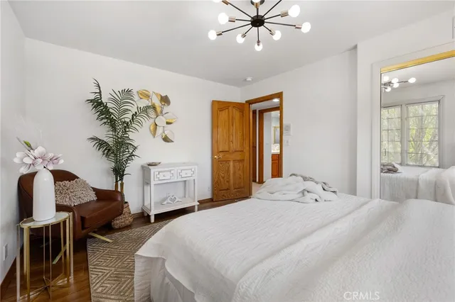 a bedroom with a bed and a mirror on the dresser