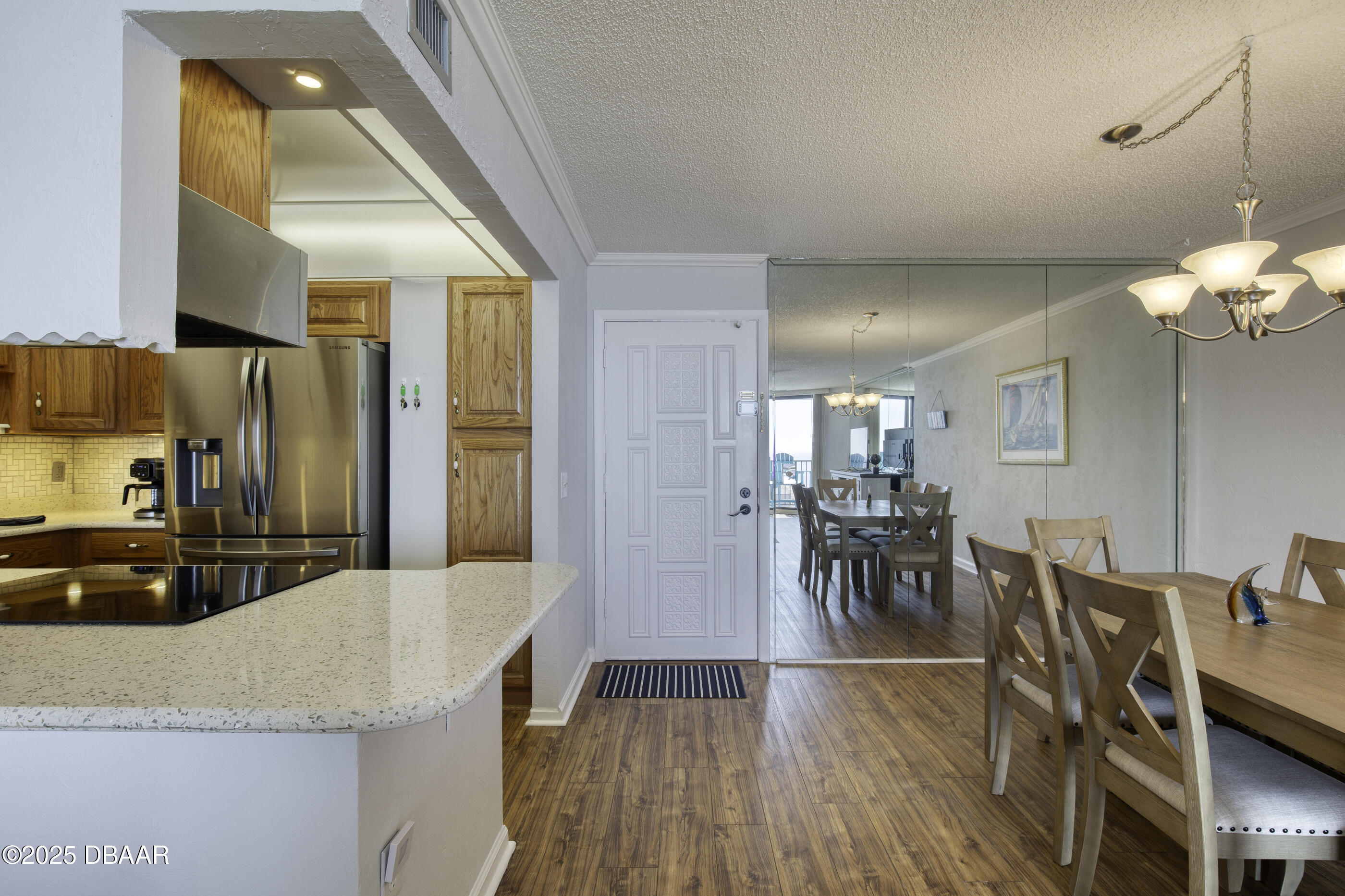 1415 Ocean Shore Boulevard, Unit 1010 Ormond Beach, FL 32176 - Photo 11 of 52 a kitchen with stainless steel appliances granite countertop a refrigerator a sink dishwasher a dining table and chairs with wooden floor