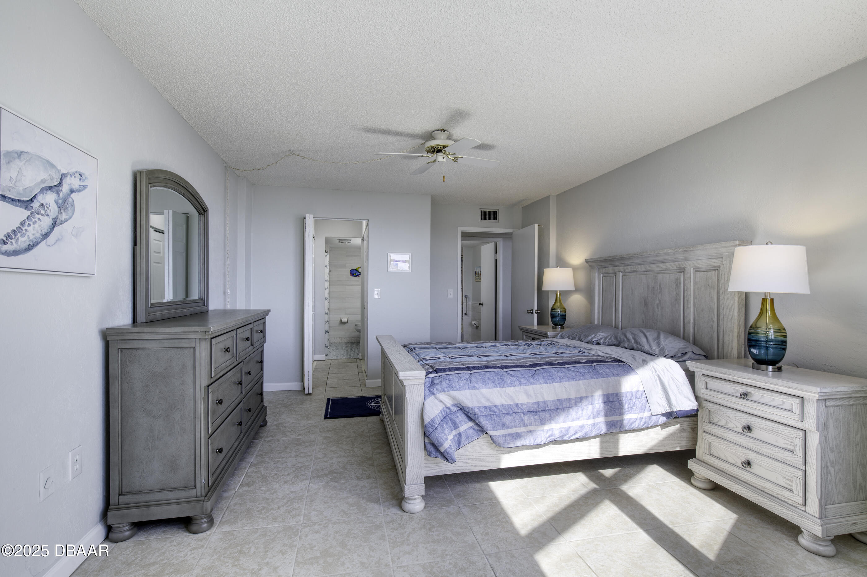 1415 Ocean Shore Boulevard, Unit 1010 Ormond Beach, FL 32176 - Photo 18 of 52 a bedroom with a bed and a chandelier