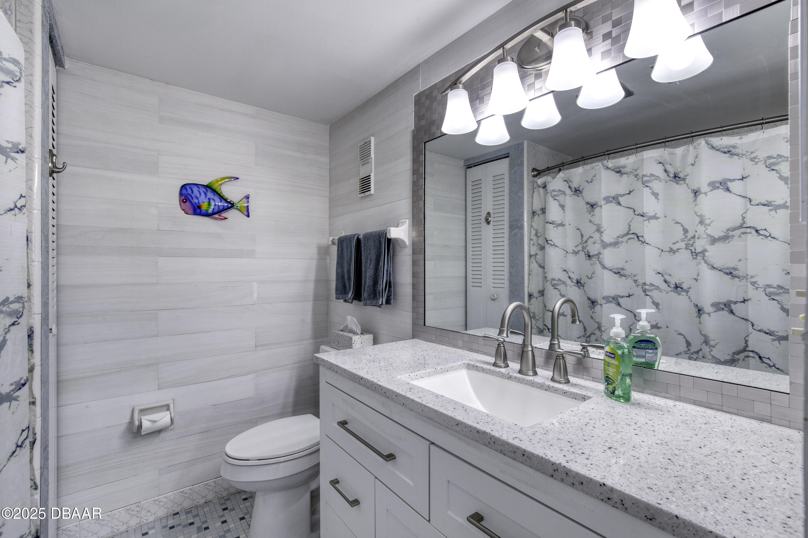 1415 Ocean Shore Boulevard, Unit 1010 Ormond Beach, FL 32176 - Photo 20 of 52 a bathroom with a sink a toilet and shower