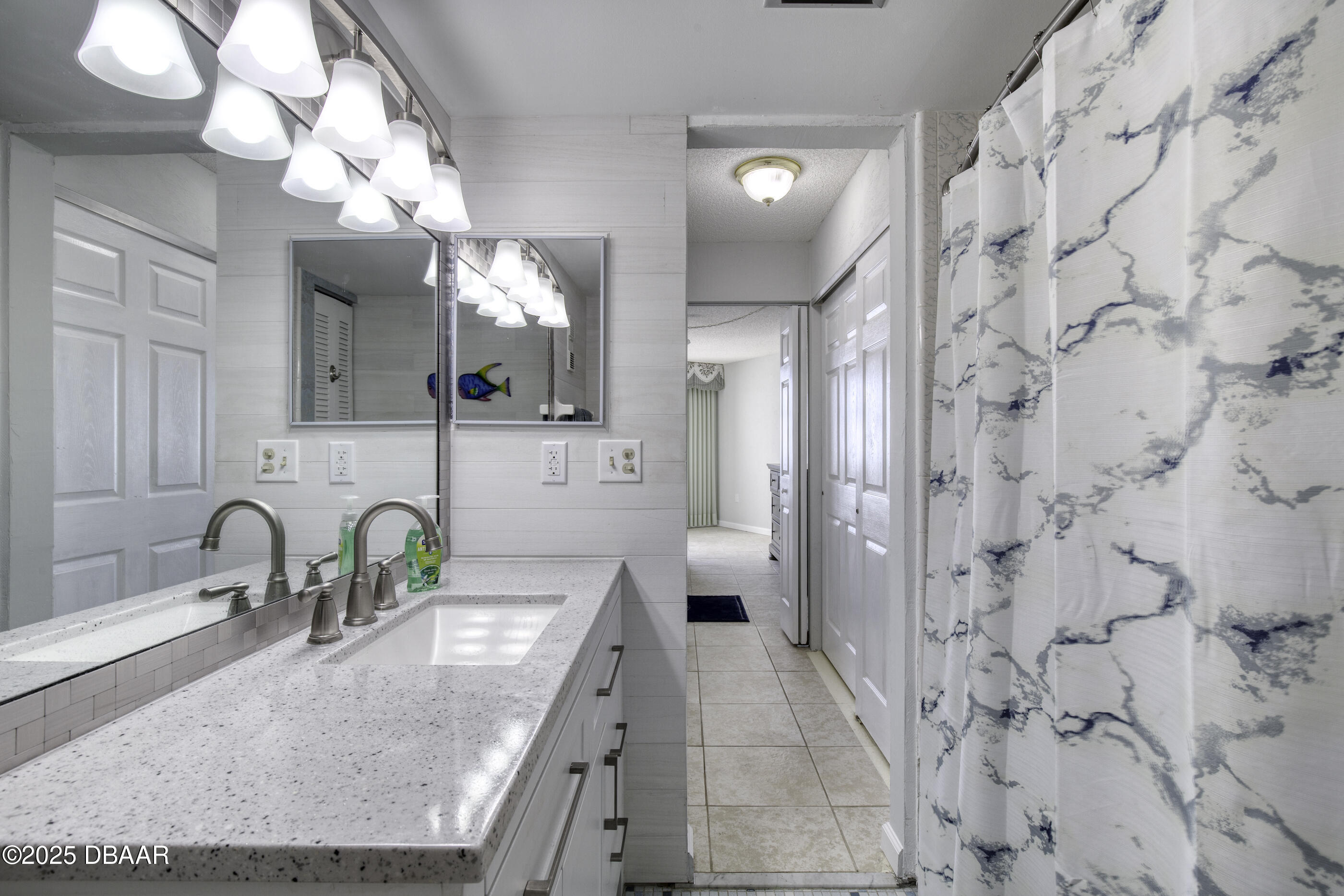 1415 Ocean Shore Boulevard, Unit 1010 Ormond Beach, FL 32176 - Photo 21 of 52 a bathroom with a granite countertop sink a toilet and a mirror