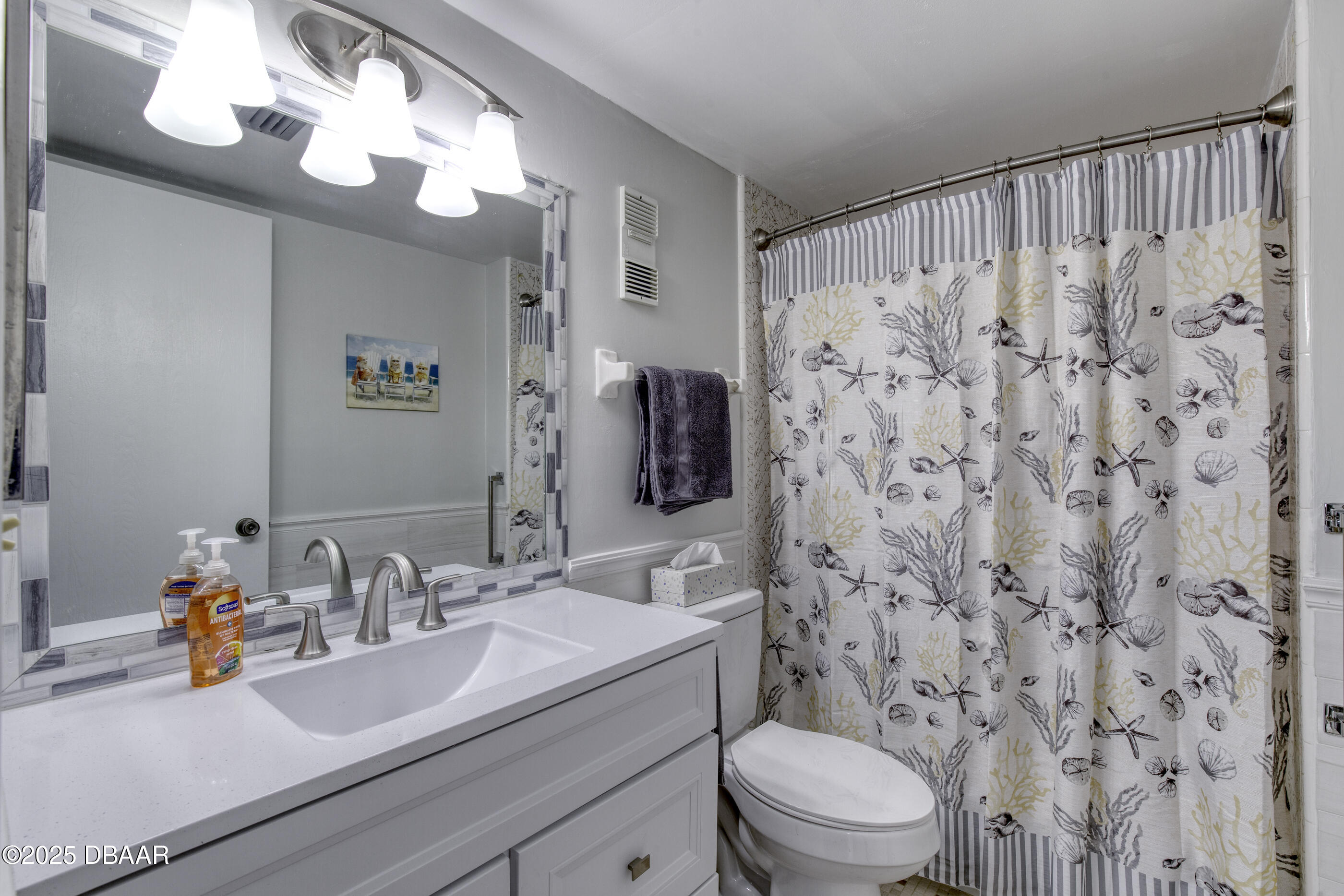 1415 Ocean Shore Boulevard, Unit 1010 Ormond Beach, FL 32176 - Photo 26 of 52 a bathroom with a sink a toilet and a mirror