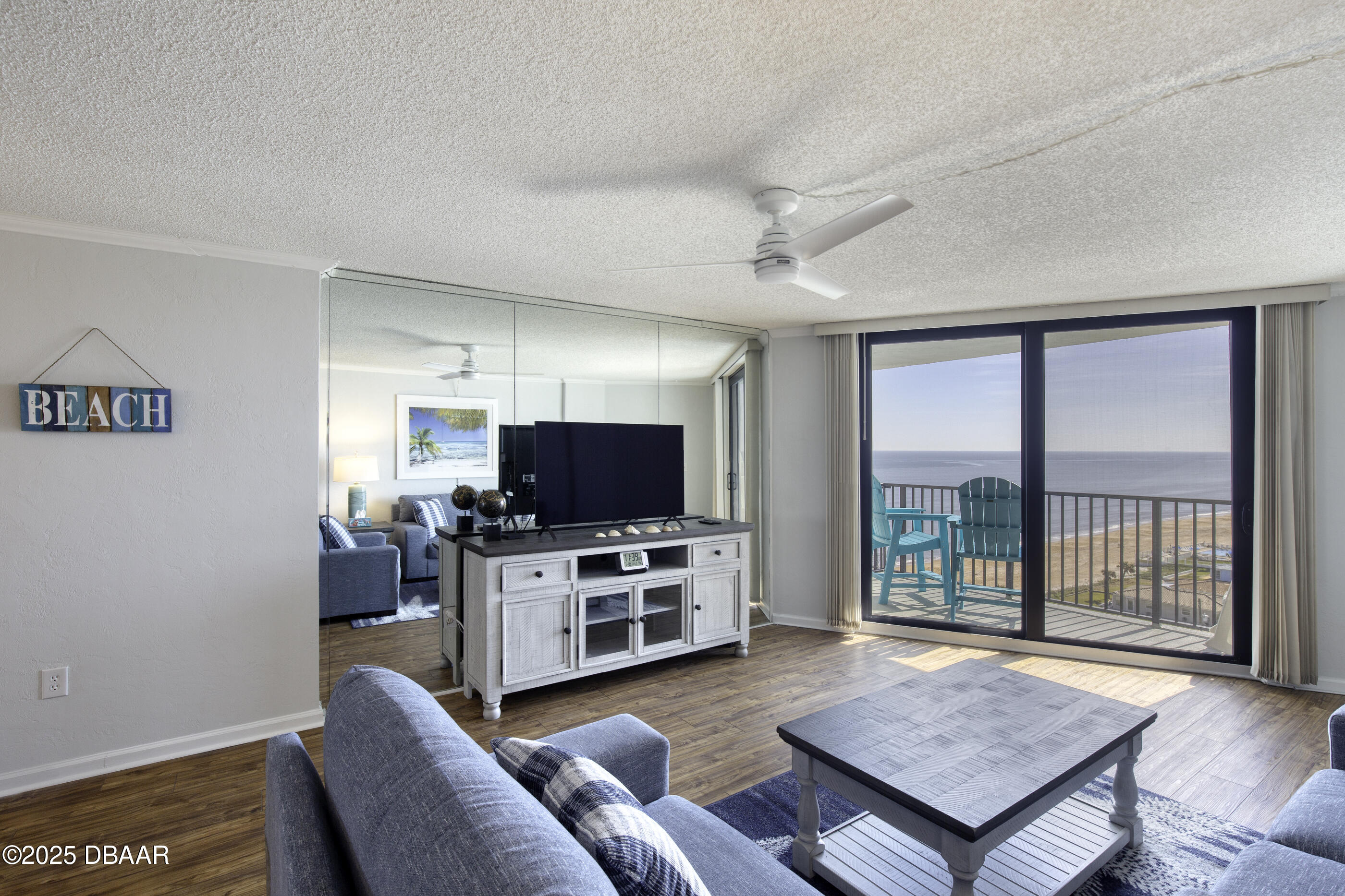 1415 Ocean Shore Boulevard, Unit 1010 Ormond Beach, FL 32176 - Photo 3 of 52 a living room with furniture and a flat screen tv