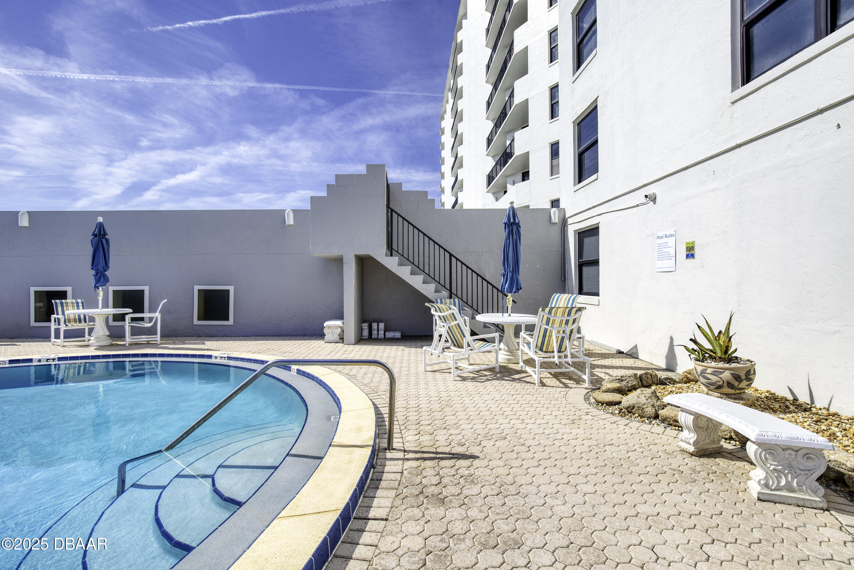 1415 Ocean Shore Boulevard, Unit 1010 Ormond Beach, FL 32176 - Photo 31 of 52 a swimming pool with outdoor seating and yard