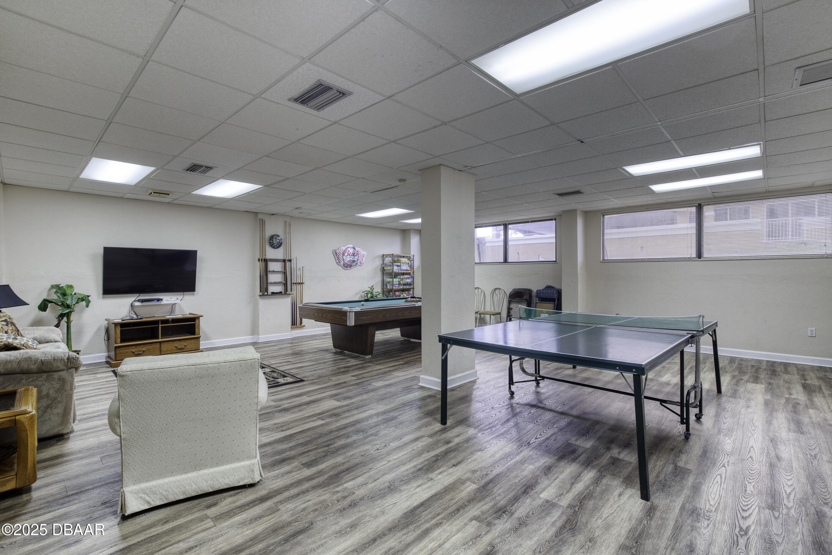 1415 Ocean Shore Boulevard, Unit 1010 Ormond Beach, FL 32176 - Photo 35 of 52 a living room with furniture a flat screen tv and kitchen view