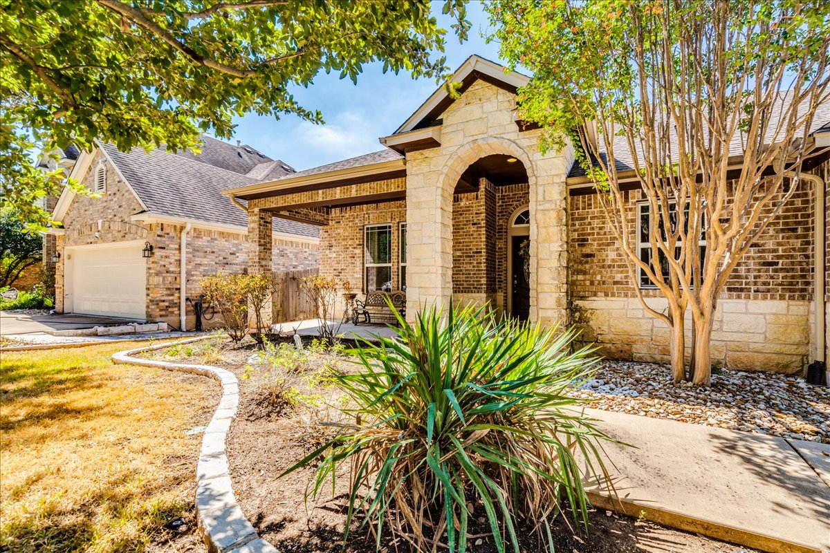 12909 Medina River Way Austin, TX 78732 - Photo 6 of 36 Stone and brick facade detailing enhances this classic exterior with its arched entryway.