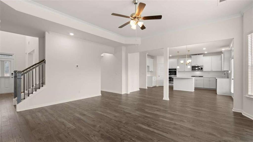 1912 Endress Circle Hampton, GA 30228 - Photo 20 of 43 a view of an empty room with wooden floor and a kitchen