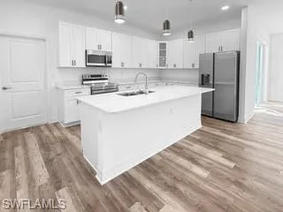 a kitchen with stainless steel appliances granite countertop a white cabinets and a refrigerator