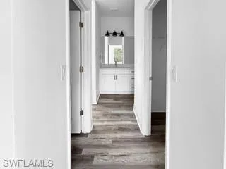 a view of a hallway with wooden floor and staircase