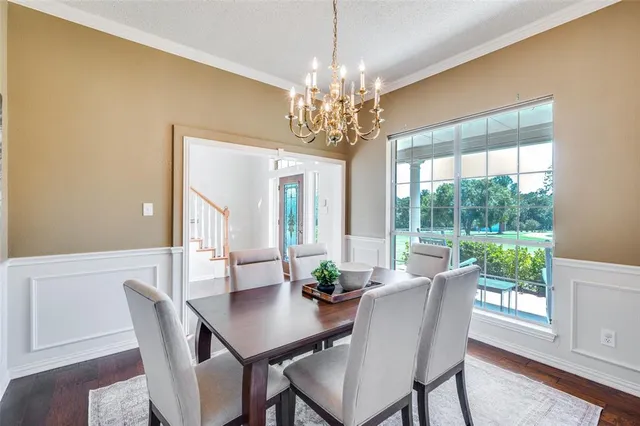 a view of a dining room with furniture a chandelier and wooden floor