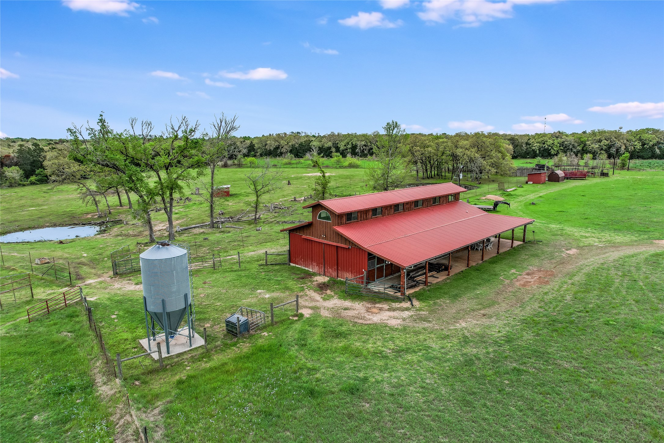 363 Paint Creek S Road, Unit A Paige, TX 78659 - Photo 15 of 28 A spacious barn and outbuildings set against a backdrop of verdant fields and mature trees.