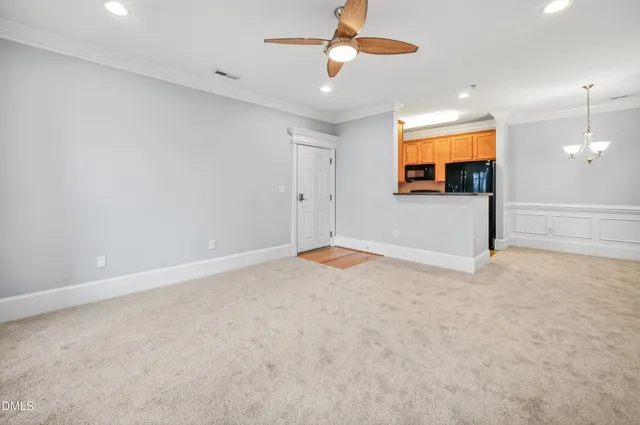 an empty room with window and ceiling fan