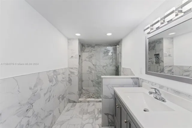 a bathroom with a sink mirror and shower