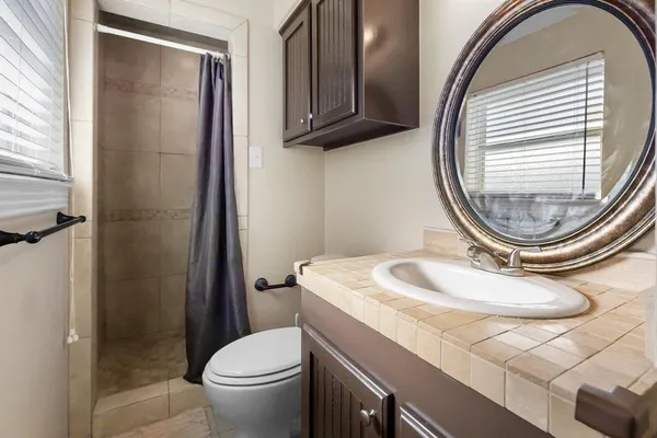 a bathroom with a sink a toilet and shower